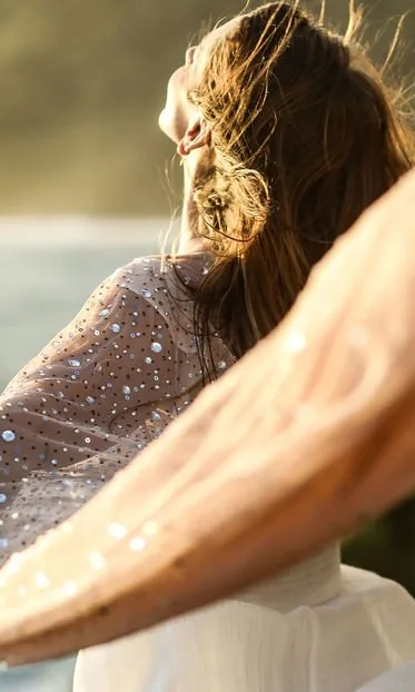 Christine turning with a sequined shawl lifting in the wind